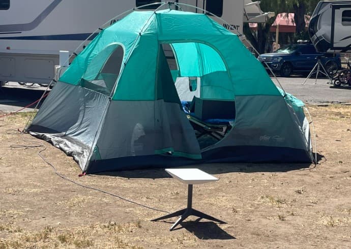 Viktor’s Starlink dish beside a tent during a camping trip in Scandinavia.
