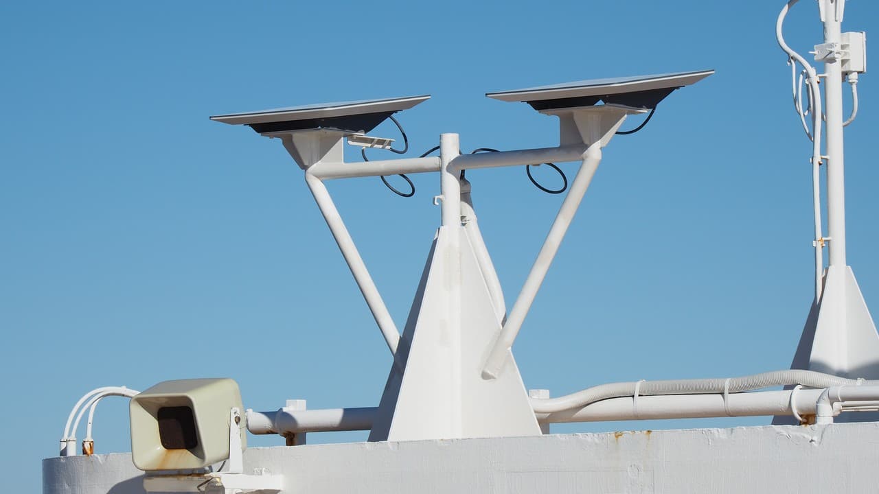 Two rectangular Starlink terminals mounted on a white ship structure against a blue sky.